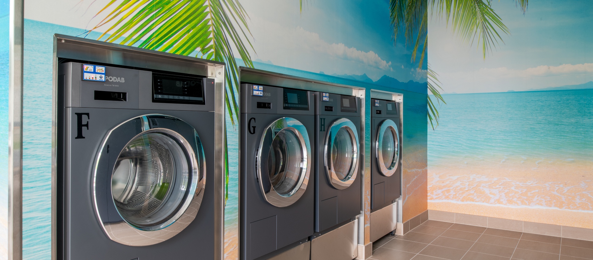 Three washing mashines in the laundry room