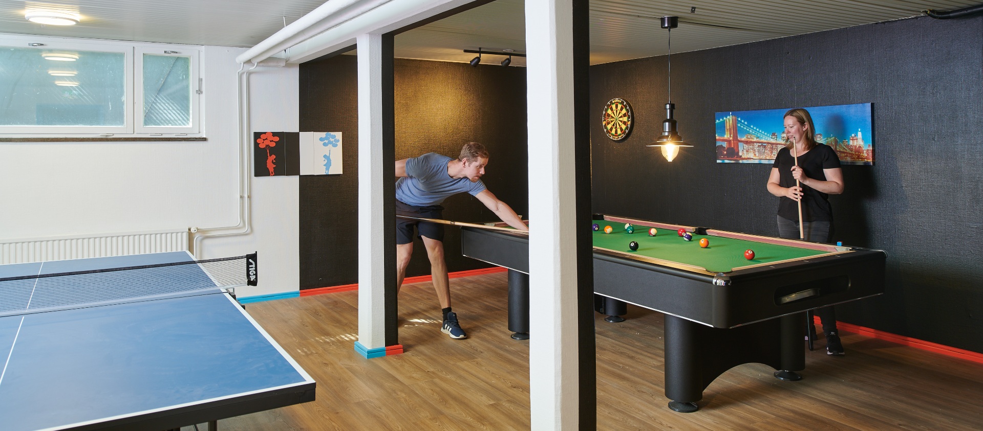 Ping pong table and two students playing pool