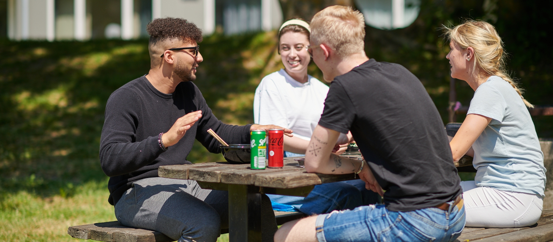 Fyra studenter äter lunch på Studentlyckans innergård